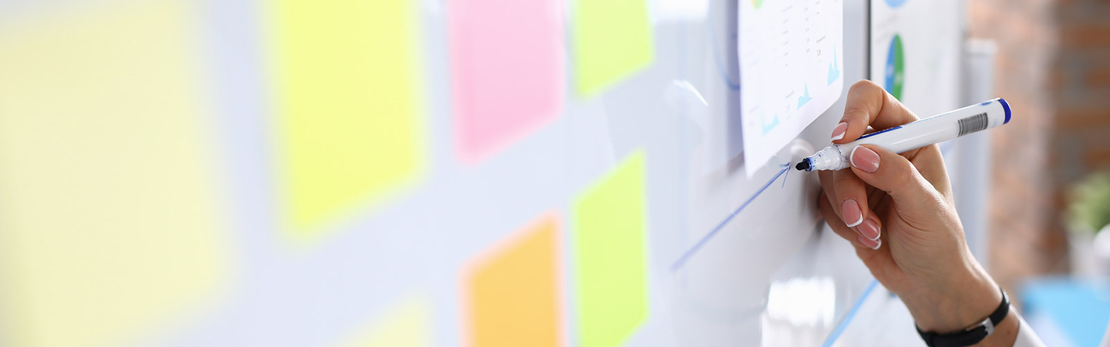 Woman draws charts on white board and holds presentation